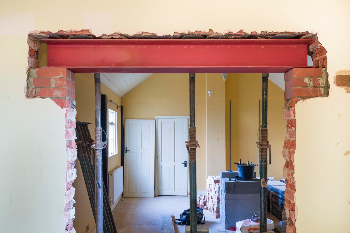 Building construction work in UK residential property with new wall opening supported by RSJ universal steel beam