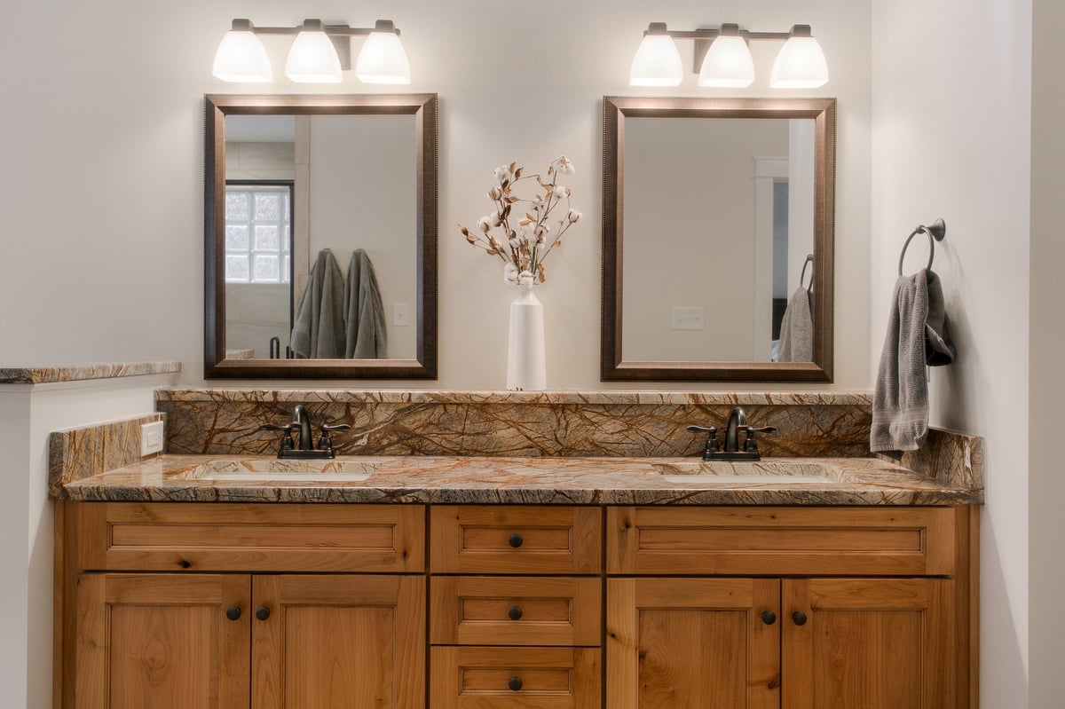 Modern double sink bathroom vanity with framed mirrors and granite countertop.