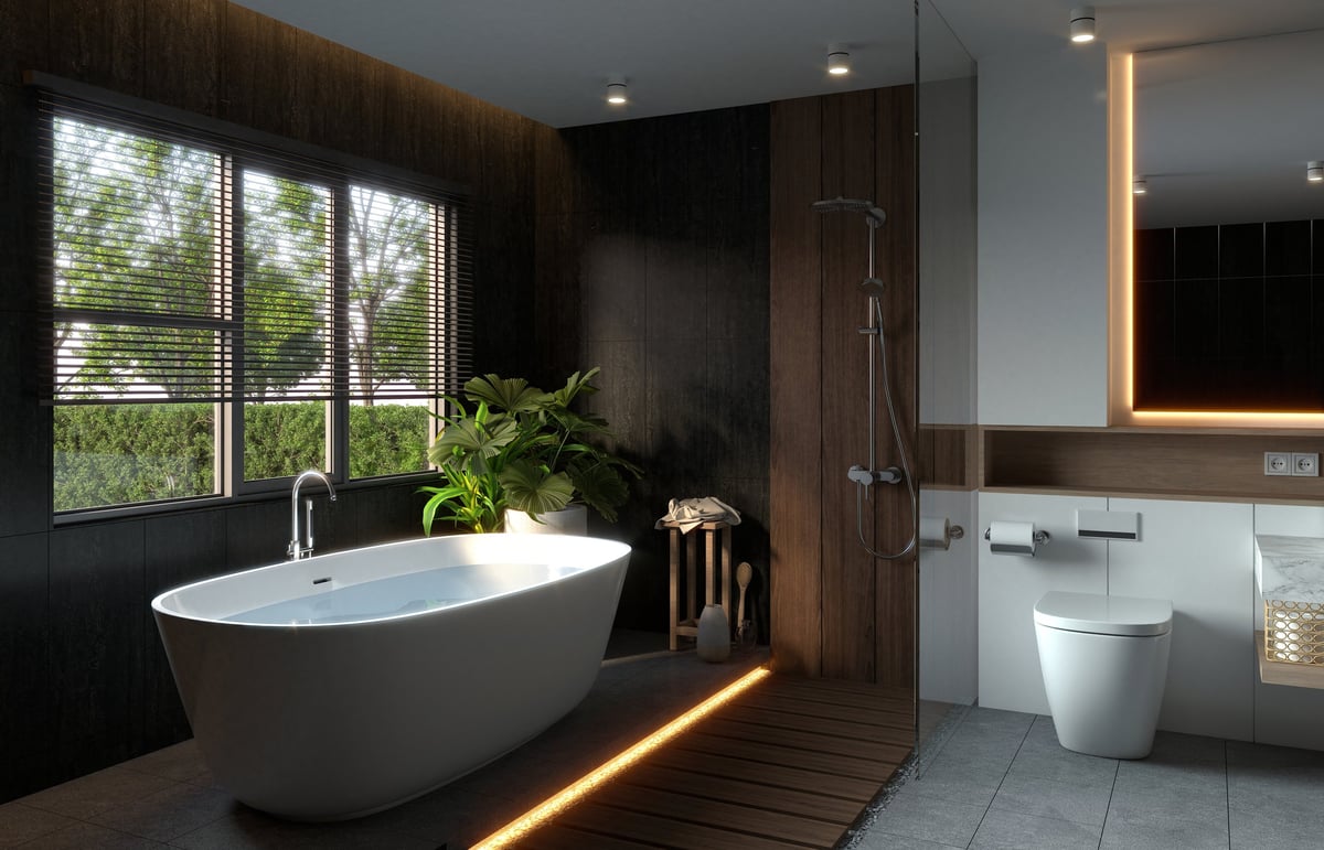 A modern bathroom with a freestanding tub, natural light, wooden accents and stylish fixtures