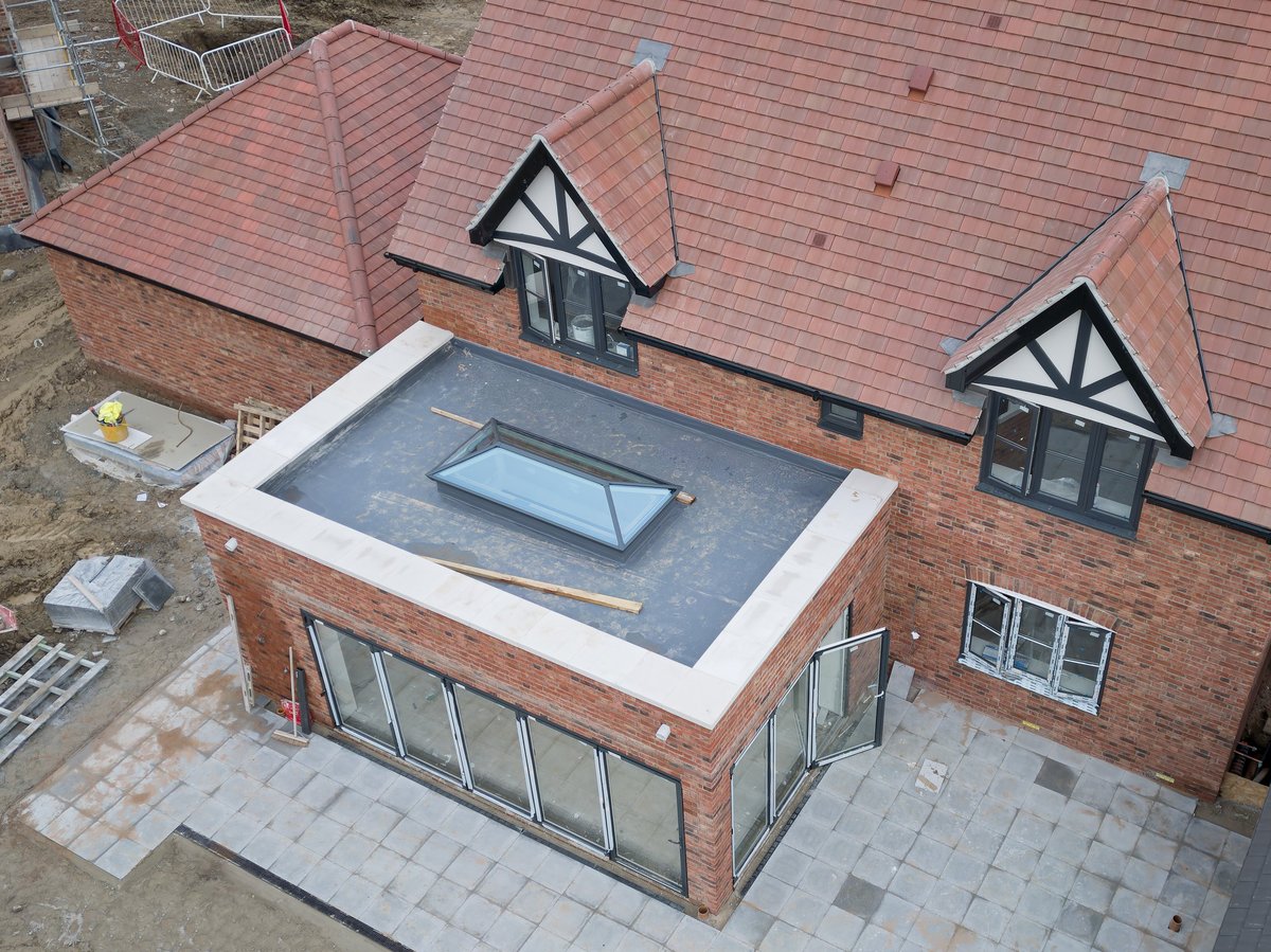 A finished large family home with a glass conservatory addition and glazed roof lantern.