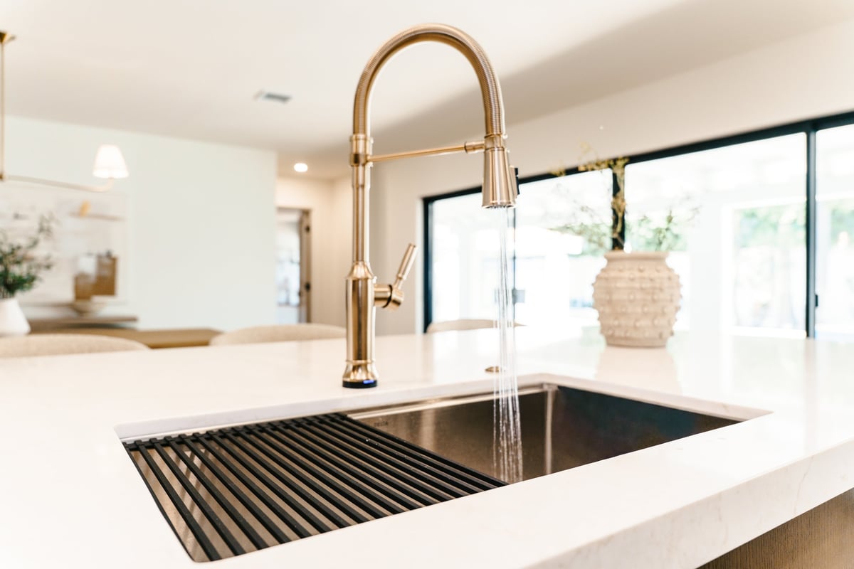 Kitchen remodeling by Just Ask Home Improvement in Toledo, Ohio — custom white quartz island, farmhouse sink, and open-concept layout.