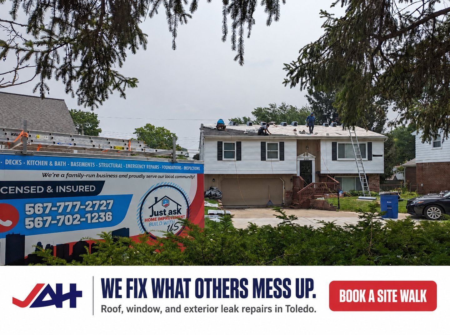 Home exterior with large blue contractor sign advertising roof and window leak repair services with phone number