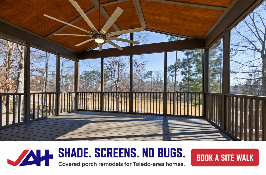Spacious covered porch with ceiling fan, wooden railings, and screened walls overlooking wooded outdoor area with bare trees