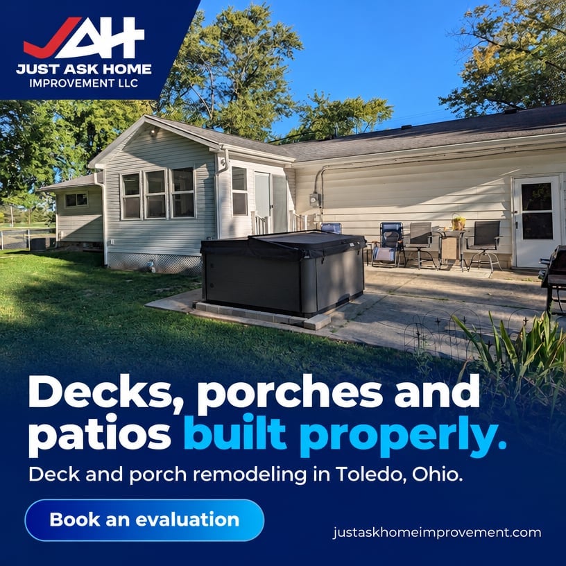 Backyard patio and deck with outdoor furniture and black hot tub next to a residential home with tan siding.